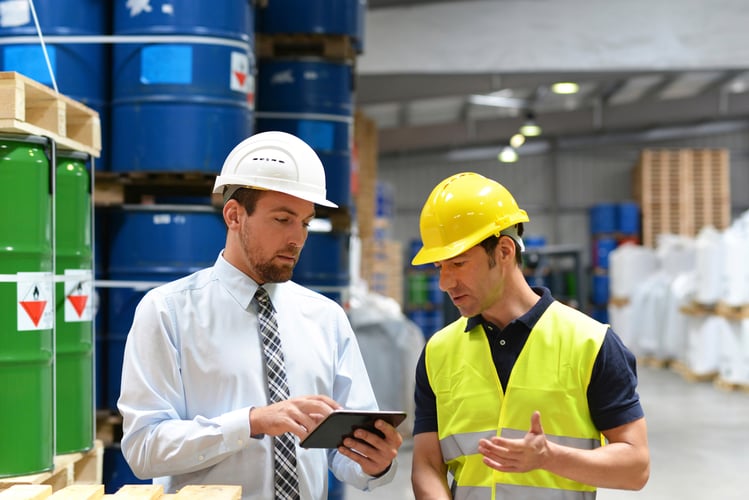 Men in chemical plant holding tablet
