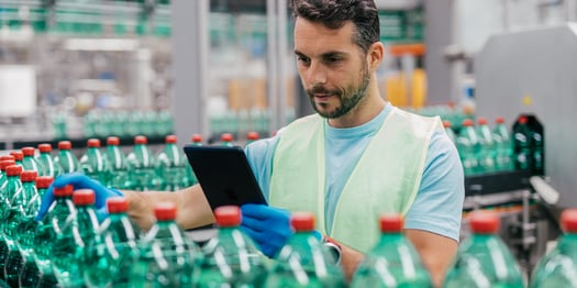 worker in bottling factory checking water bottles