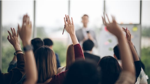 People raising their hands in a presentation
