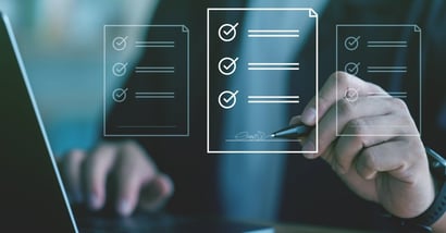 Hand signing a digital document on a virtual checklist display above a laptop